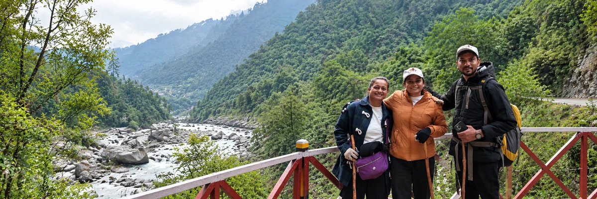 Travellers on a footbridge above a Himalayan river valley